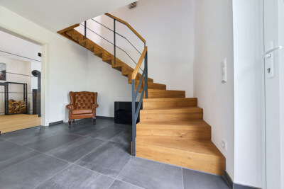 Viertelgewendelte Faltwerktreppe aus Eiche mit einem Flachstahlgeländer