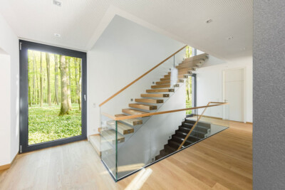 moderne Kragarmtreppe mit Holzstufen, Holz- und Glasgeländer